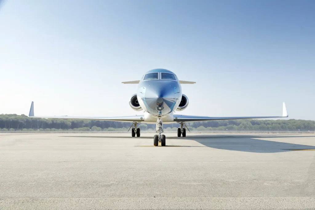 Straight-on front view of Gulfstream G550 SN:5562, OE-LCZ, highlighting its twin jet engines, wide stance, and aerodynamic build on an open runway.