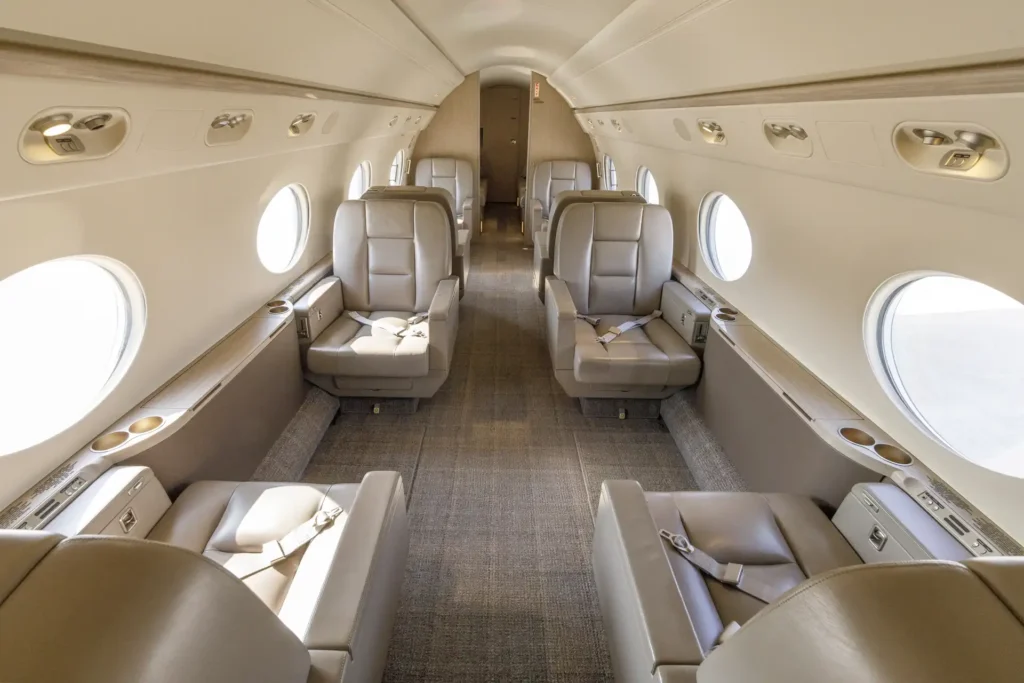 Wide-angle view of the main cabin in Gulfstream G550 SN:5562, featuring eight executive leather seats with armrests, cup holders, and window views in a spacious layout.
