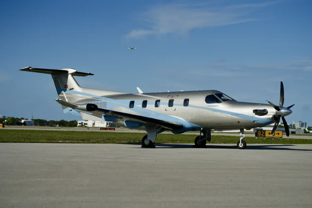 Side profile of a Pilatus PC12 NGX taxiing on the runway in daylight
