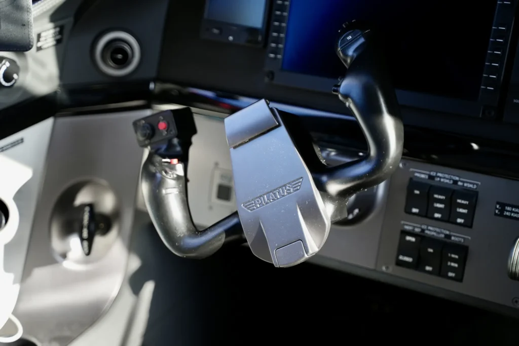 Close-up of the yoke control with Pilatus branding inside a PC12 NGX cockpit.