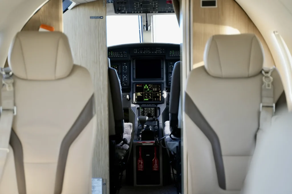 View from passenger cabin toward cockpit of a Pilatus PC12 NGX with modern avionics.