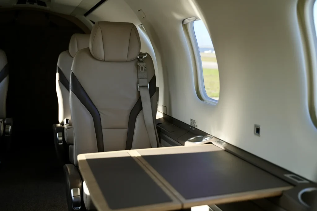 Pilatus PC12 NGX cabin seat with extended table near window.
